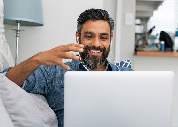 Smiling man using computer for virtual therapy.